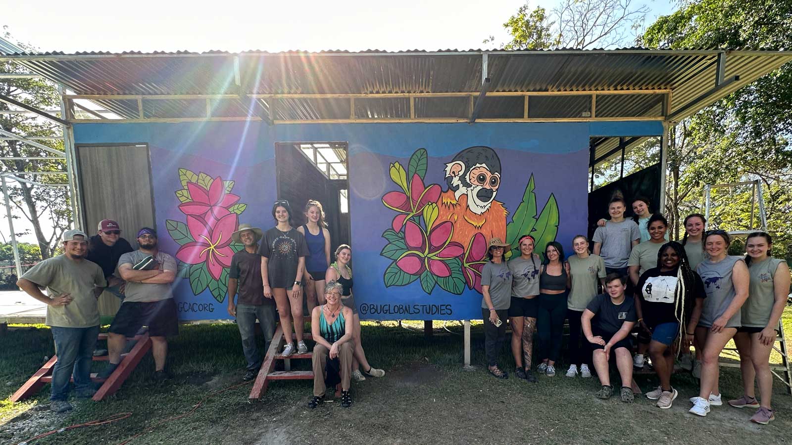 2023-3-Costa-Rica-Mural Global Citizen Adventure Corps students gathered around mural they painted at animal rescue center in Costa Rica