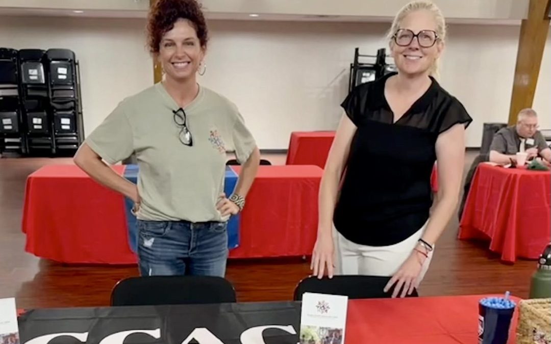 women at information table