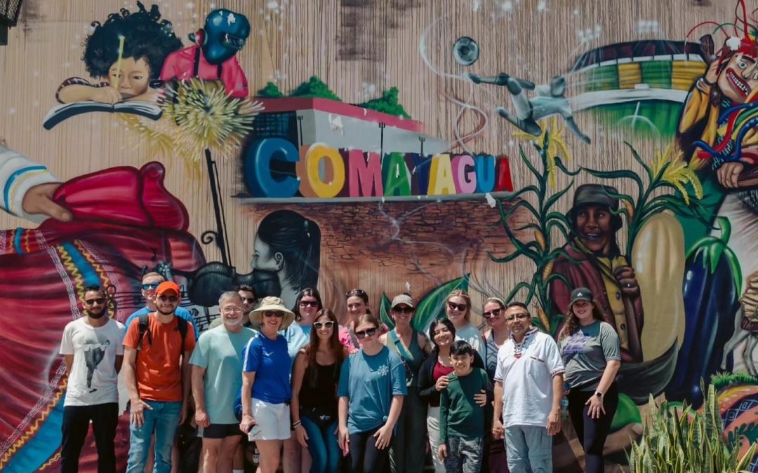Honduras GCAC participants with local partners in front of a mural