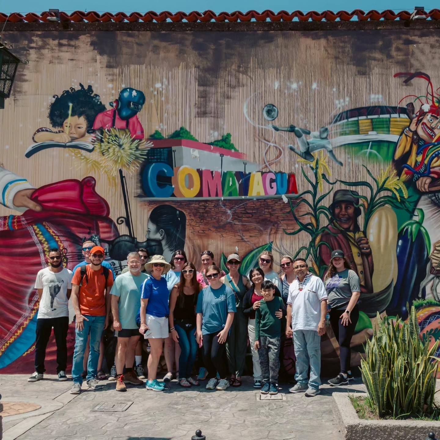 Honduras GCAC participants with local partners in front of a mural