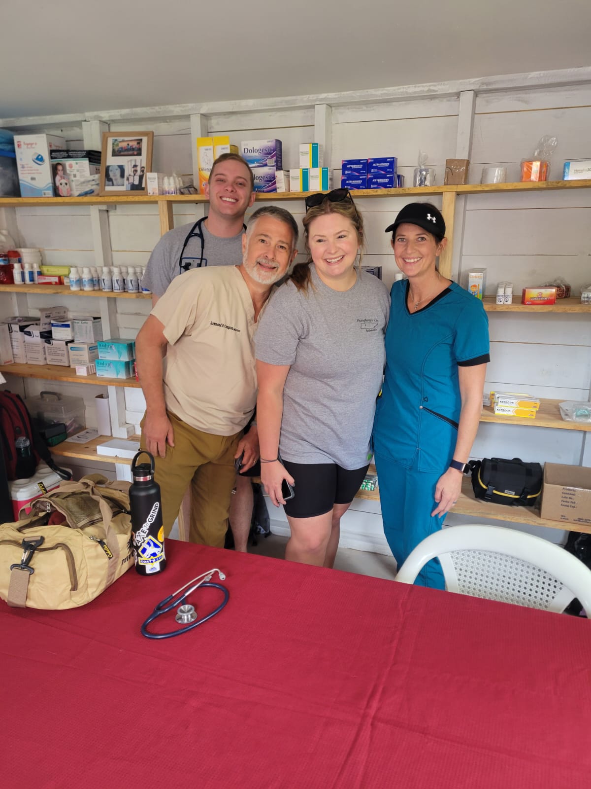 Four team members stand in front of wall of medications