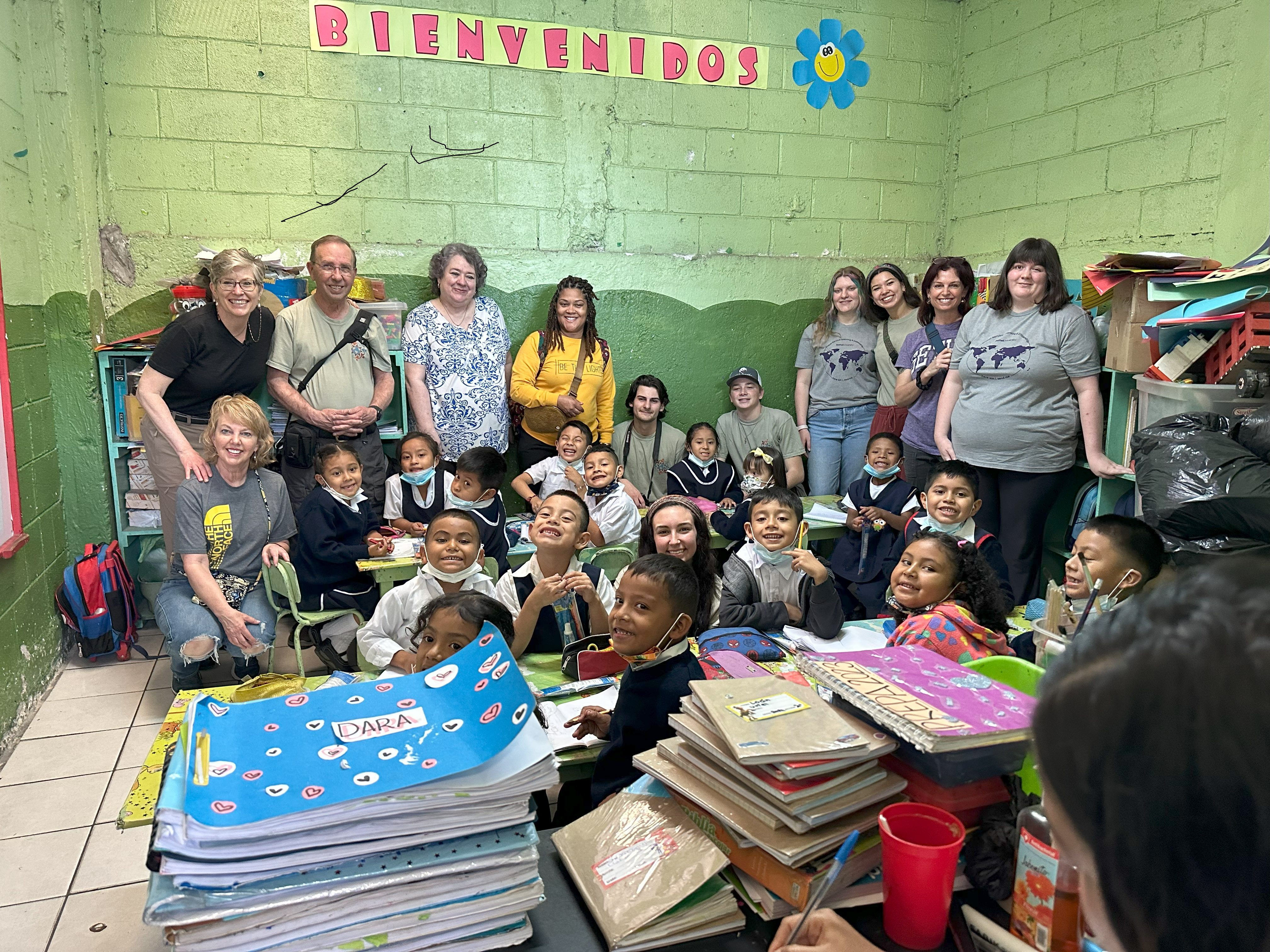adults in back of classroom of students