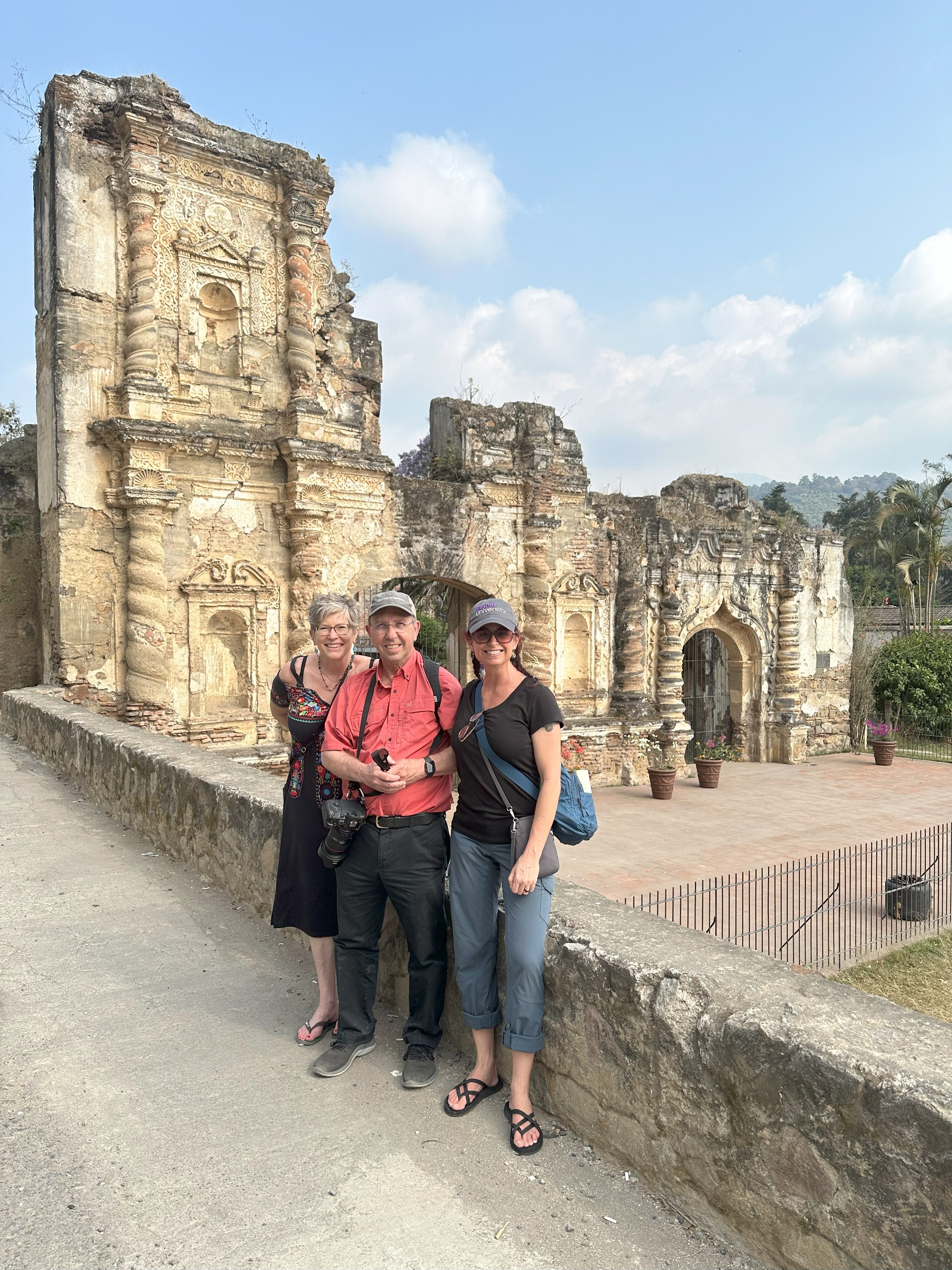Julie Hill, Joel Washburn, and Stacie Freeman standing in front of ruins
