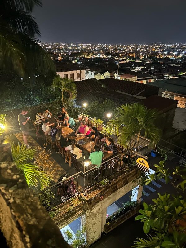 City at night with group sitting at rooftop restaurant
