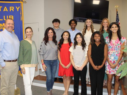 UC Rotary - Europe Group group standing in frotn of Rotary sign